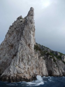 Waves crash onto the island of Capri during a cloudy morning.