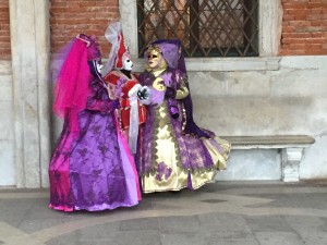 A group of three costumed people tries to find the most elegant backdrop to  compliment their outfits.